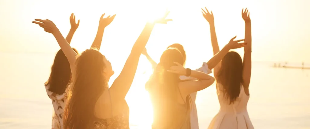 Mujeres levantando las manos al sol, simbolizando esperanza tras el uso de Cytotec